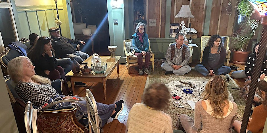 People sitting in a circle on the floor and on chairs.